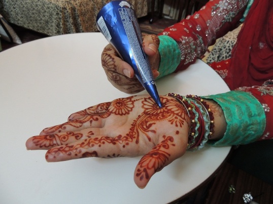 Ladies apply mehndi (henna) on Chand Raat.